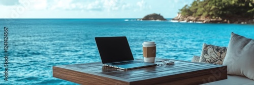 Laptop and coffee with ocean view outdoor workspace.
