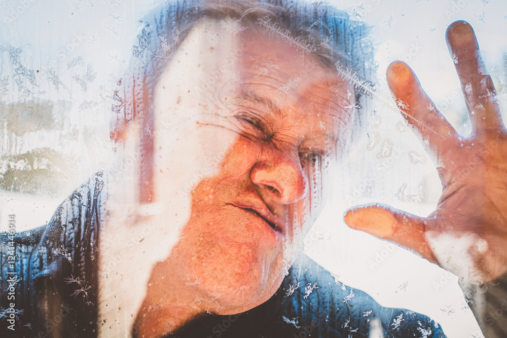 Fototapeta premium Älterer Mann klebt an der Fensterscheibe