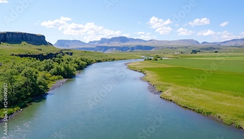 River flows through green valley, mountains background