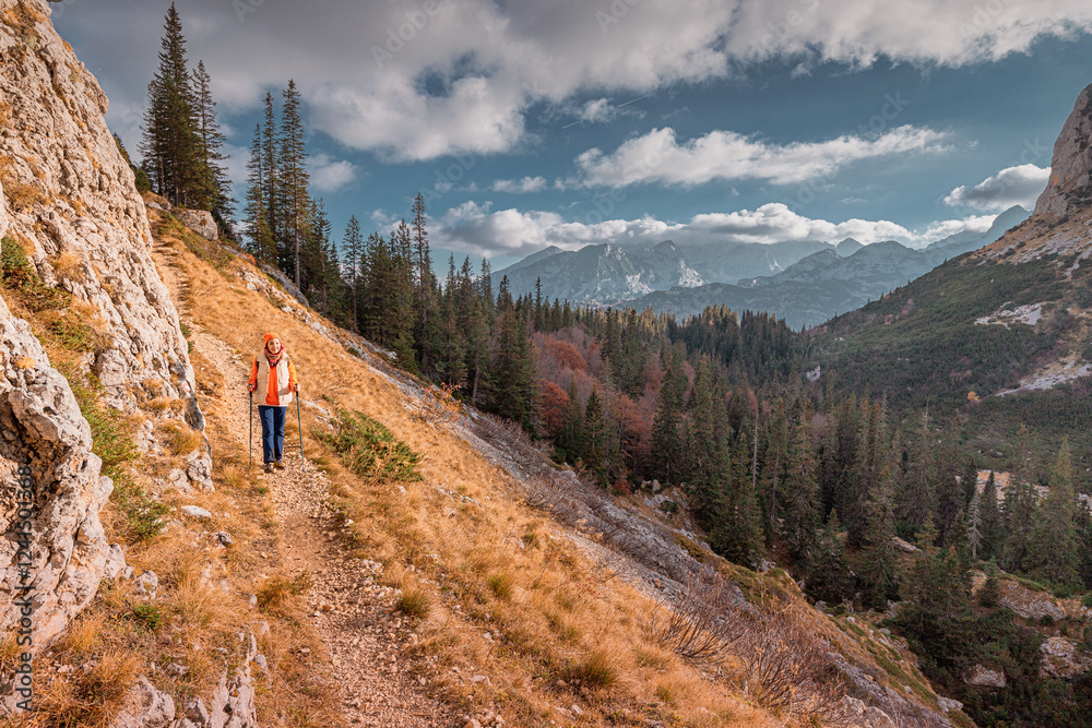 Woman hiking on mountain trail enjoying scenic view in Durmitor National Park, Montenegro