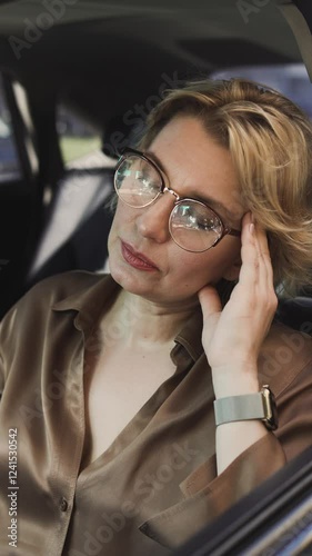 Mature senior woman resting in car touching temples feeling terrible headache, migraine