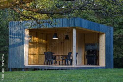 Obraz na płótnie Modern wooden gazebo in a serene forest setting. Contemporary cube design with table and chairs. w salonie