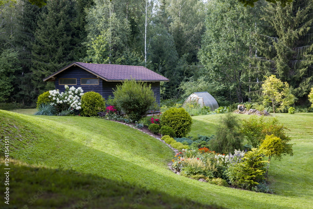 Obraz premium Charming wooden cabin nestled in a lush green landscape with a beautiful garden and forest backdrop.