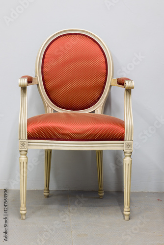 Elegant, classic armchair possibly Louis XVI style. Ornate carving and red patterned upholstery.