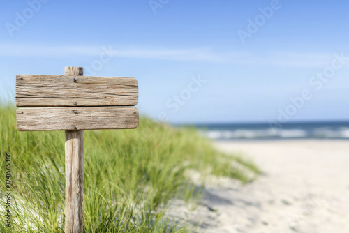 Wallpaper Mural rustic wooden signpost stands on sandy beach, surrounded by green grass and clear blue sky, evoking sense of tranquility and adventure Torontodigital.ca