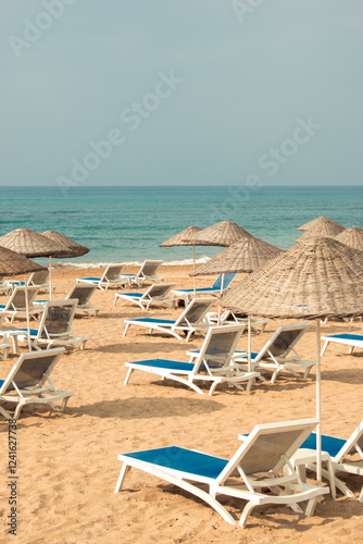 Empty deck chairs on the sandy beach by the beautiful sea.