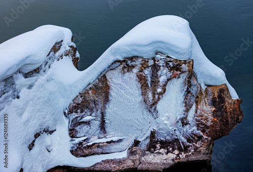 Ice encased rock along the Middle Fork of Flathead River in Glacier National Park, Montana, USA.
