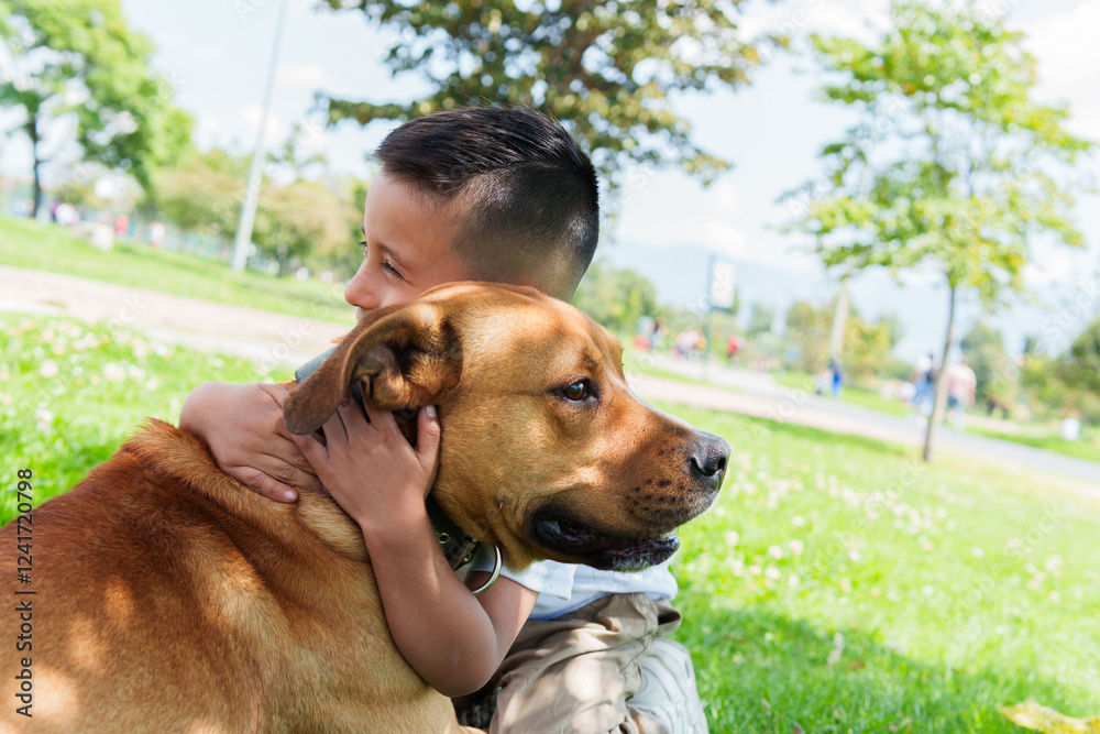 A boy is smiling and hugging his pet dog in the park. Concept of love, tenderness, best friend A boy is smiling and hugging his pet dog in the park. Concept of love, tenderness, best friend