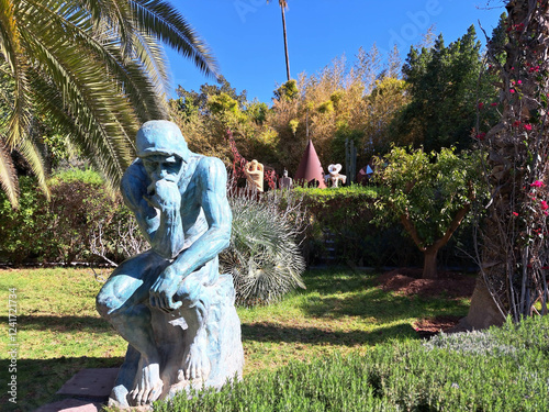 Contemplative Sculpture Nestled Among Lush Greenery in a Tranquil Garden Setting