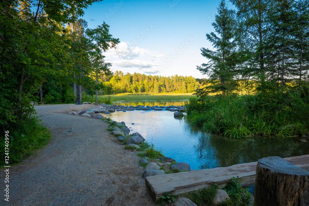 Gravel walkway along the Mississippi River at its source, where the water flows out of Lake Itasca in Minnesota over a small rock dam.