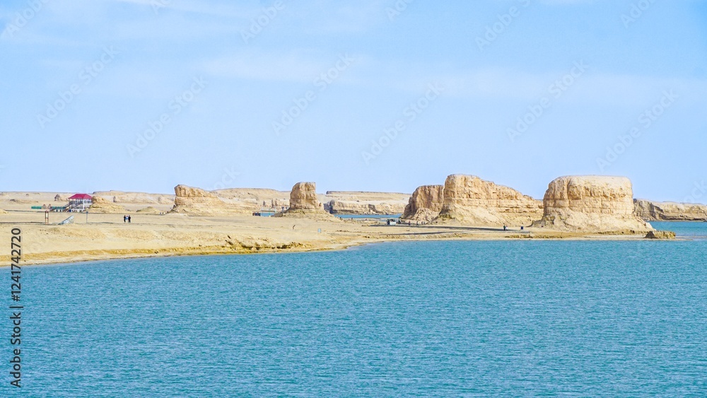 Unique rock formations along the serene shoreline of a tranquil lake on a clear day Unique rock formations along the serene shoreline of a tranquil lake on a clear day