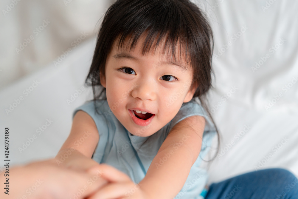 Joyful Child Reaching Out with a Bright Smile in a Cozy Indoor Setting Joyful Child Reaching Out with a Bright Smile in a Cozy Indoor Setting