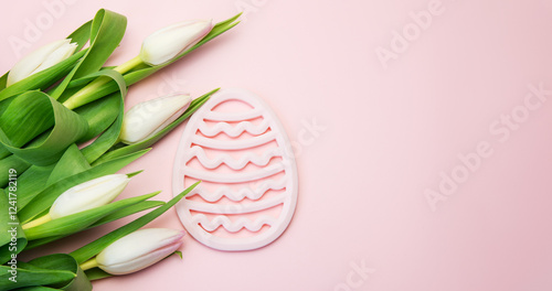Bouquet of fresh cut pink tulips and Easter eggs symbol on a pink background. Spring Festival.