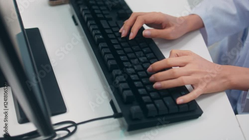 Busy Asian female doctor working on a computer in medical office at a hospital. Healthcare Professional woman typing on keyboard for research, working on medical cases, Treatment results at workplace.
