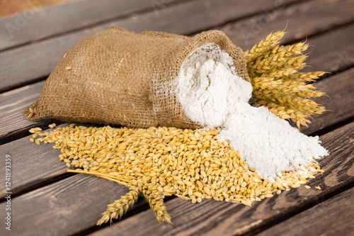 Wheat Grains and flour on desk background photo