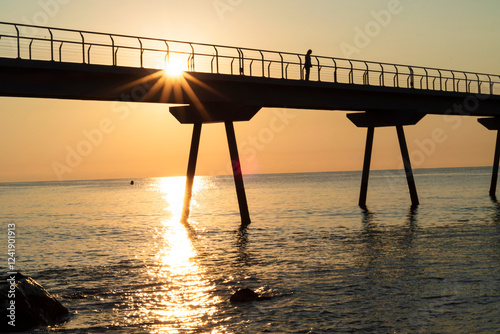 fotografie a apusului de soare pe plaja de lângă Podul Petrolului din orașul Badalona photo