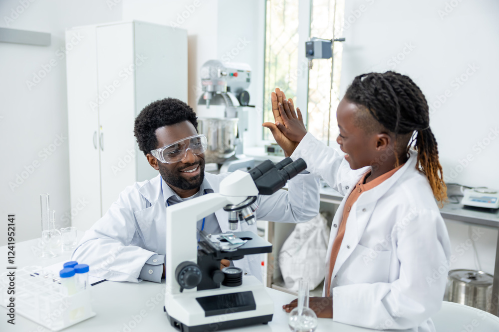 Fototapeta premium Teacher and student in lad coats looking happy and contented