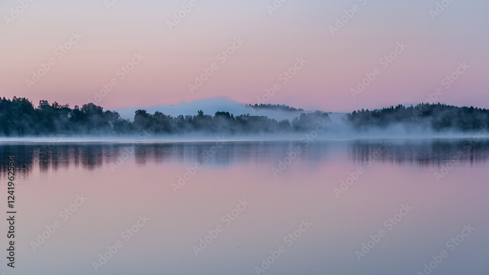 Fototapeta premium Early summer night by a calm lake in Finland with fog rising from the water