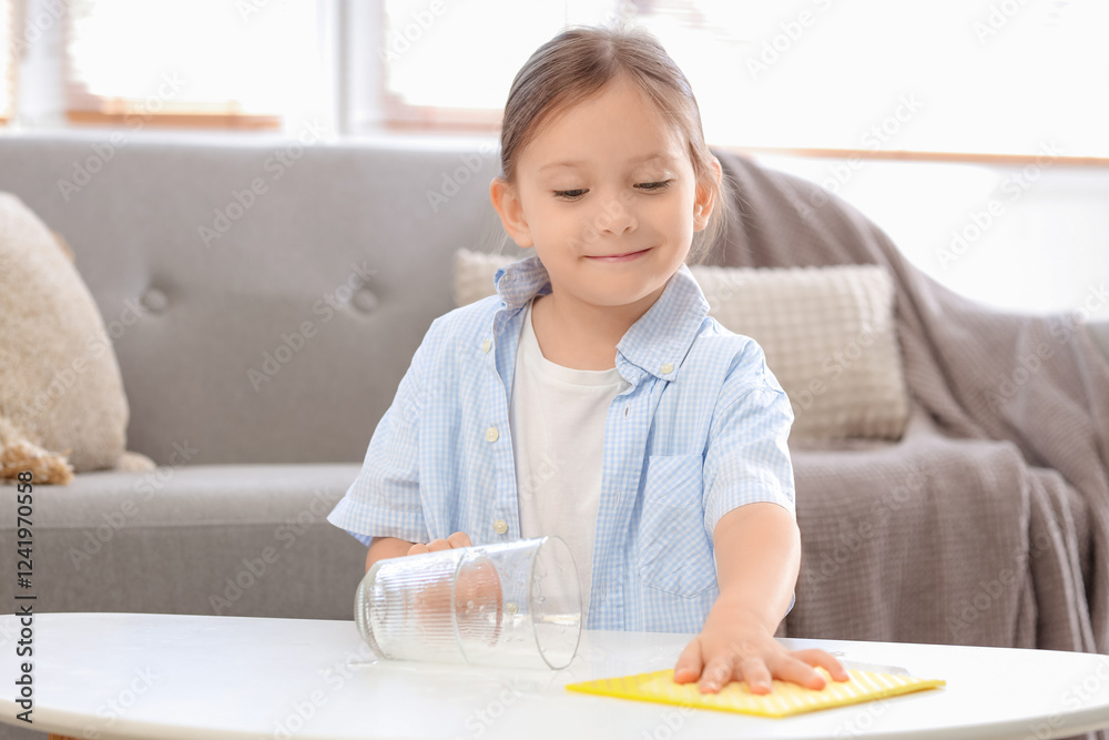 Cute little girl wiping spilled water on table at home Cute little girl wiping spilled water on table at home