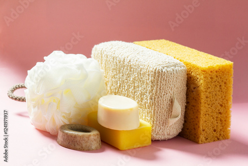Obraz na płótnie Set of bath accessories, sponges of different sizes and shapes and handmade soap on a pink background. w salonie