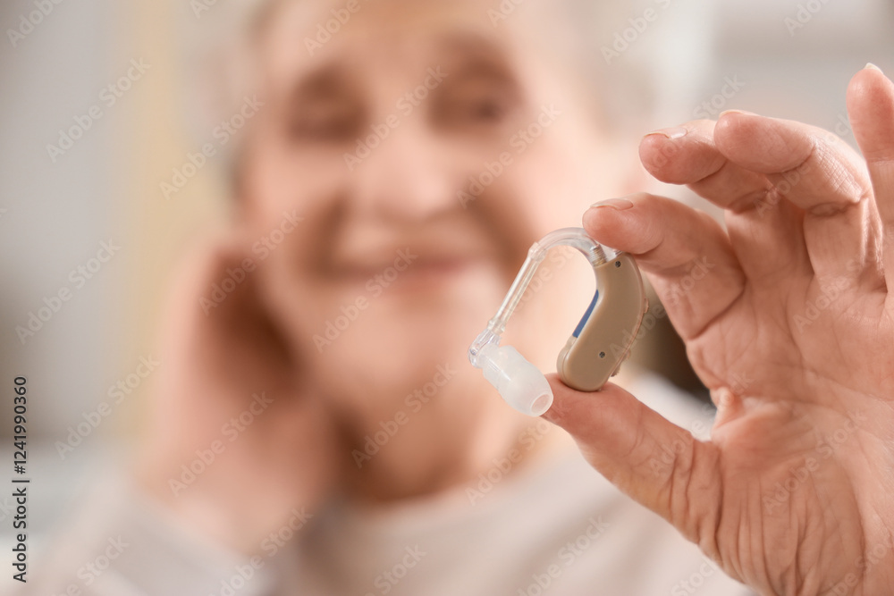 Senior woman with hearing aid at home, closeup Senior woman with hearing aid at home, closeup