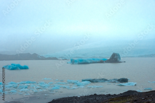 Icebergs from the melting Fjallsjokull Glacier under the rain,  Iceland photo