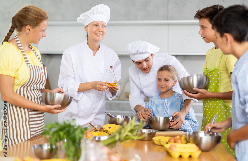 During culinary class, female cook instructs children on how to make fluffy pancakes while male assistant helps child who is struggling to mix ingredients in bowl. During culinary class, female cook instructs children on how to make fluffy pancakes while male assistant helps child who is struggling to mix ingredients in bowl.