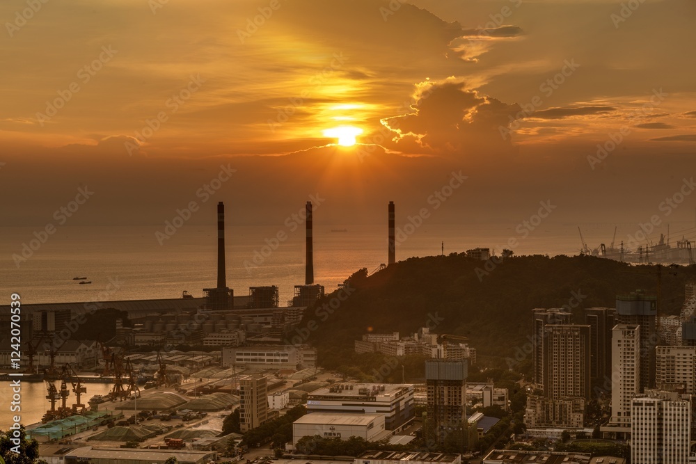 Sunset view over the coastal city with industrial structures and tranquil waters in the background Sunset view over the coastal city with industrial structures and tranquil waters in the background