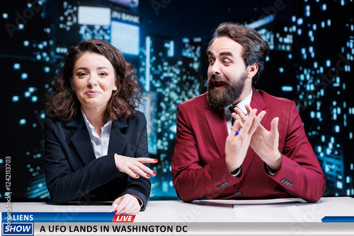 Presenters team reveals ufo landing in washington, talking about alien invasion in usa while broadcasing live in newsroom. Man and woman journalists reporting latest national information. photo