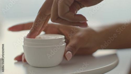 Wallpaper Mural A young African American woman engages in her skincare routine at home, using a skincare product. She seems relaxed and focused on pampering her skin with care. Torontodigital.ca