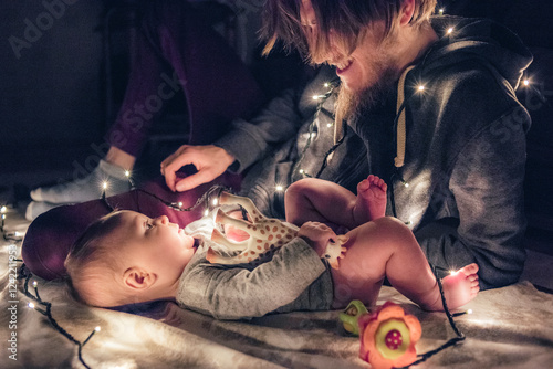 Father and Baby in dark room with Fairy Lights photo