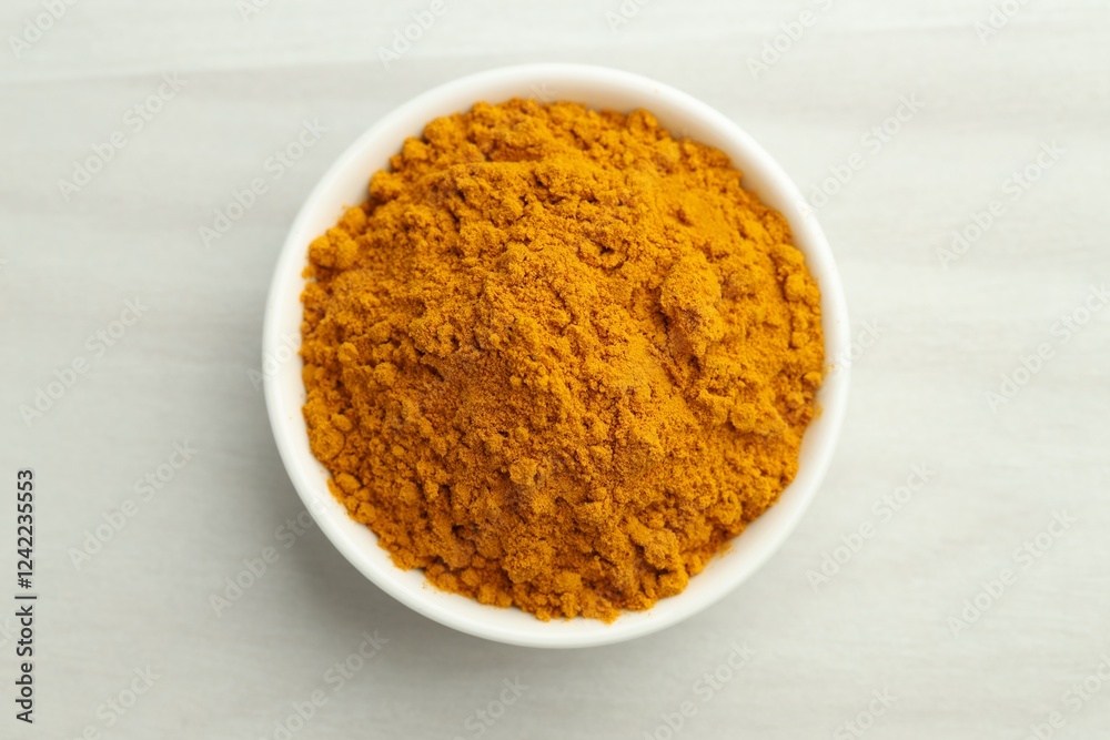 Turmeric powder in bowl on white table. Top view Turmeric powder in bowl on white table. Top view