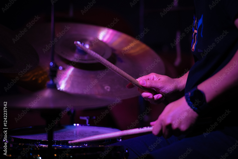 Naklejka premium Drummer playing jazz with drumsticks, focus on hands and cymbals.