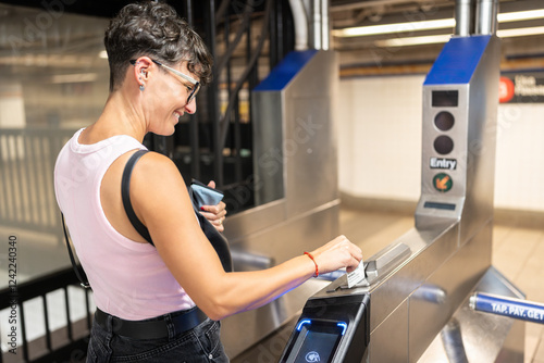 Tourist using omny card at turnstile entering new york city