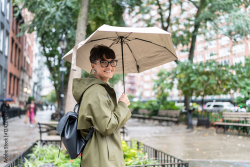 Woman holding umbrella walking in New York City during rainy day photo