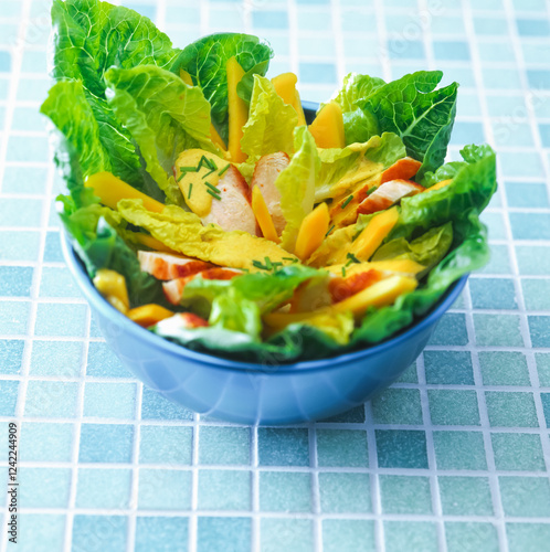 Fresh salad with fried chicken,  romaine lettuce, mango and herbs