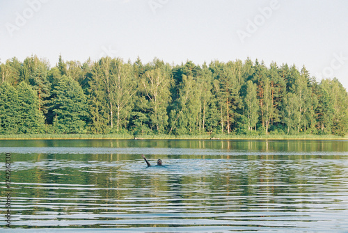 Man swimming in the forest lake photo