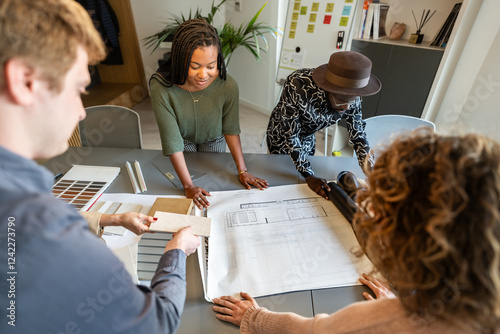 Architects analyzing blueprints and materials in coworking office