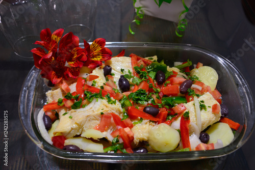 Traditional Portuguese dish Bacalhoada with salted cod, potatoes, olives, and vegetables, served in a rustic plate. Rich in flavor and cultural heritage. photo