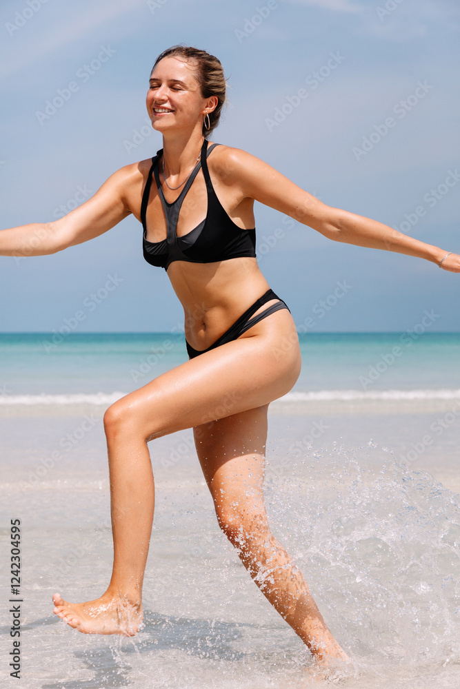 Woman enjoys a sunny day at the beach while splashing in water Woman enjoys a sunny day at the beach while splashing in water