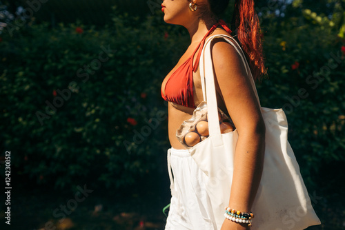 Anonymous female carrying groceries with tote bag