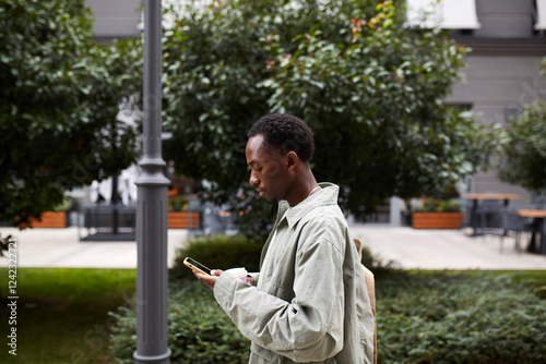 Man texting on his phone in town photo