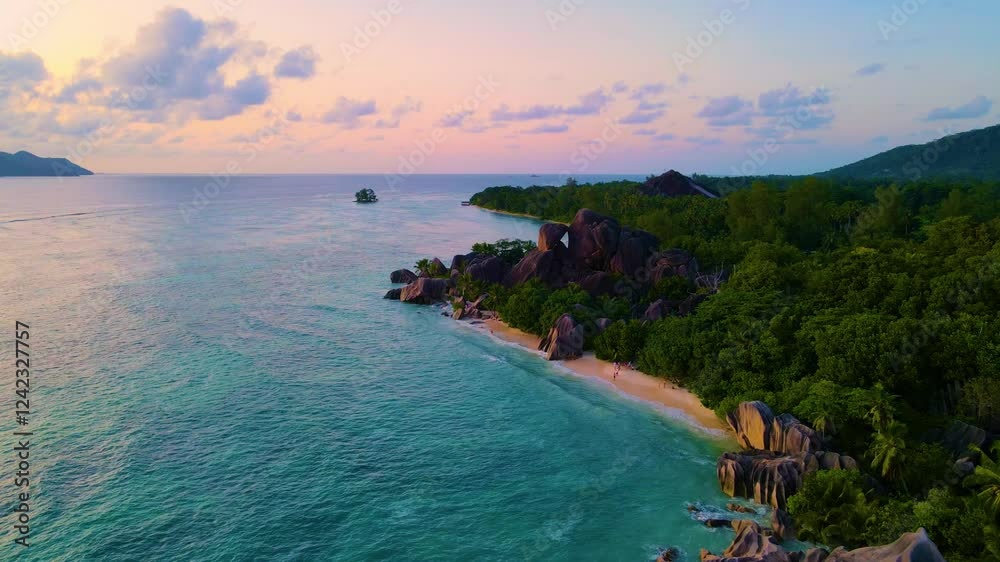 Experience the serene coastline of Seychelles as the sun sets over crystal-clear waters. Lush greenery and unique rock formations create an enchanting tropical paradise. Anse Source D'Argent La Digue 