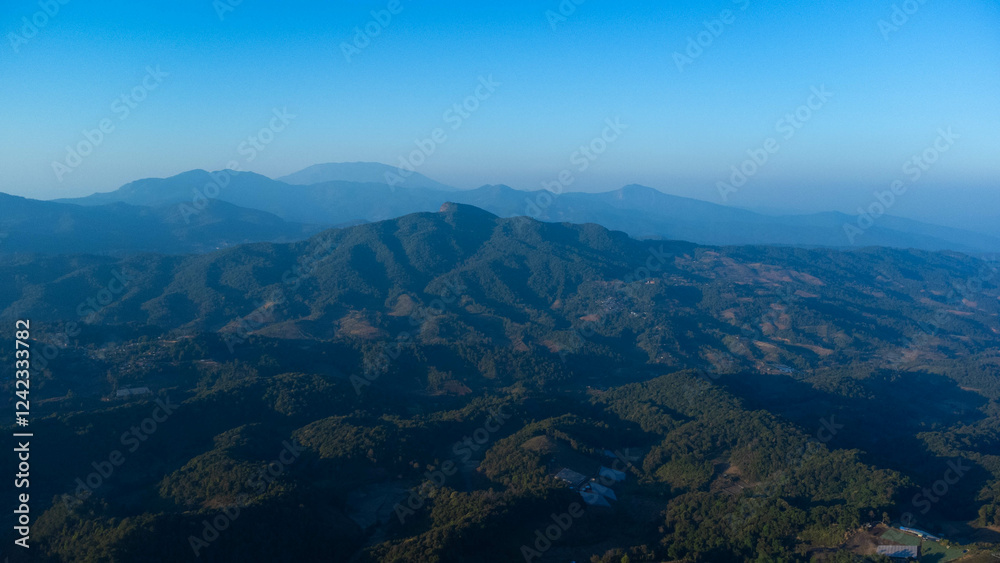Beautiful sunrise on the mountain in winter. The sun shines down on a serene mountain landscape covered with tropical trees and the calm river in the early morning. Beautiful sunrise on the mountain in winter. The sun shines down on a serene mountain landscape covered with tropical trees and the calm river in the early morning.