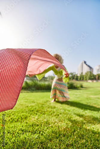 Joyful Girl Laying Out Picnic Blanket photo