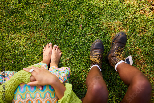 Anonymous friends sitting on green grass