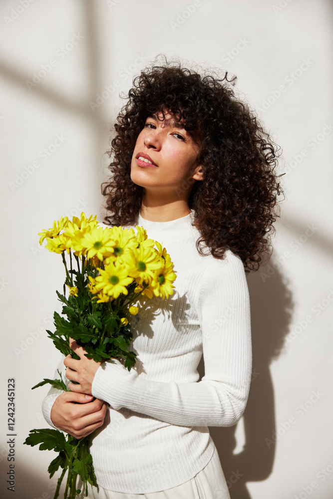 Confident curly hair female Holding Vibrant Yellow Flowers Confident curly hair female Holding Vibrant Yellow Flowers
