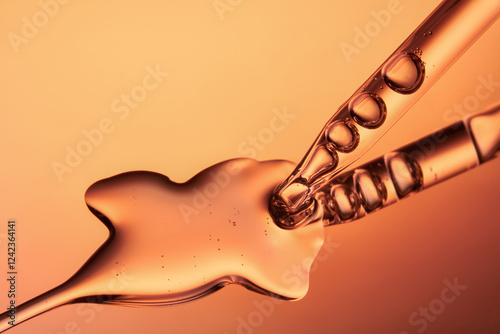 Close up of a pipette dispensing liquid on orange yellow background.