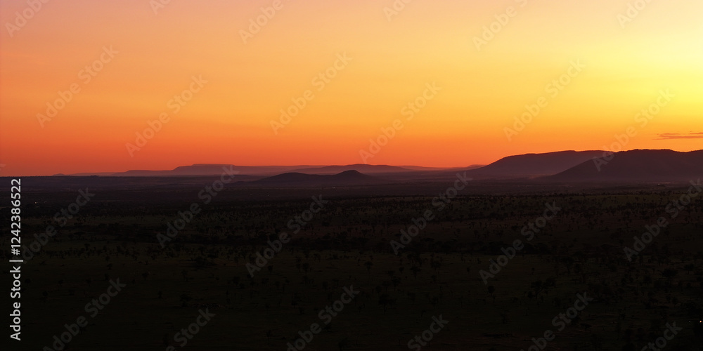 Bright orange Tanzanian sunset, with beautiful Savannah range Bright orange Tanzanian sunset, with beautiful Savannah range