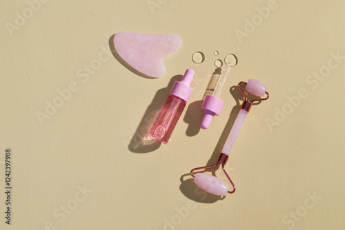 Pink Facial Beauty Tools and Skincare Products on Yellow Background photo